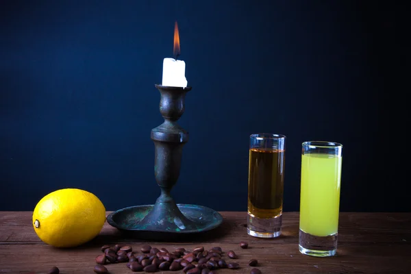 Dos bebidas diferentes en una mesa de madera con un candelabro. teñido —  Fotos de Stock