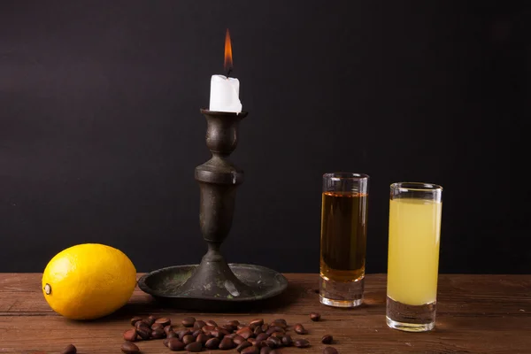 Dos bebidas diferentes en una mesa de madera con un candelabro . — Foto de Stock