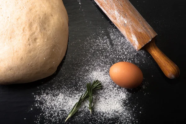 Flour, rolling pin, egg, rosemarin and dough for pie — Stock Photo, Image