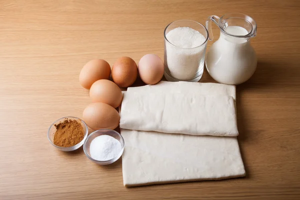 Молоко, сахар, какао, тесто, яйца и соль на деревянной доске . — стоковое фото