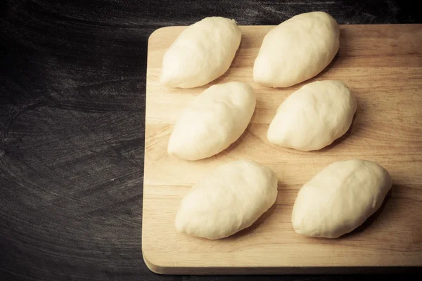 Pieces of dough on the wooden board. Toned — Stock Photo, Image