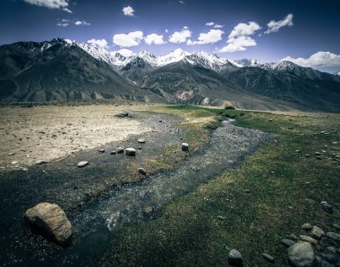 Vadi ve karla kaplı dorukları yarış hızlı akışında