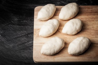 Ahşap tahta üzerinde hamur parçaları. Tonda