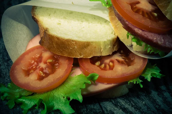 Sandwich zawiązał sznurka na teksturowane deska. Stonowanych — Zdjęcie stockowe
