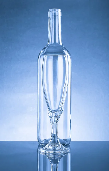 Lege fles en een leeg glas helder glas. Met reflectie — Stockfoto