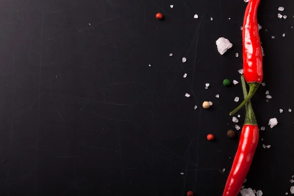 Red hot chilli papričkou s mořskou solí a barevným pepřem na černém — Stock fotografie