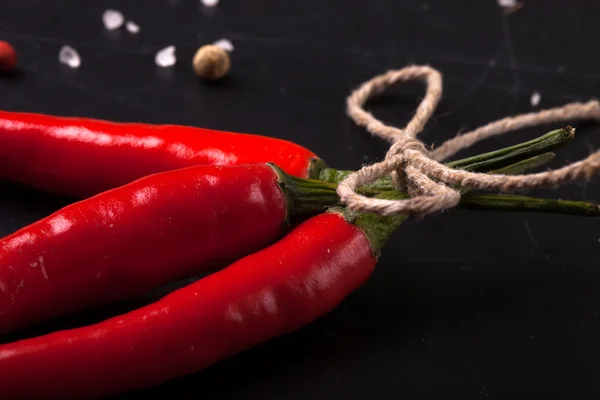 Red hot chili peper met zeezout en gekleurde peper op zwart — Stockfoto