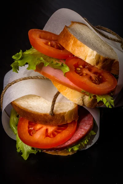 Sandwich zawiązał sznurka na teksturowane deska. Stonowanych — Zdjęcie stockowe
