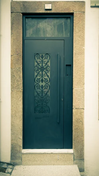 Metal door with patterns on the stone wall. Toned — Stock Photo, Image