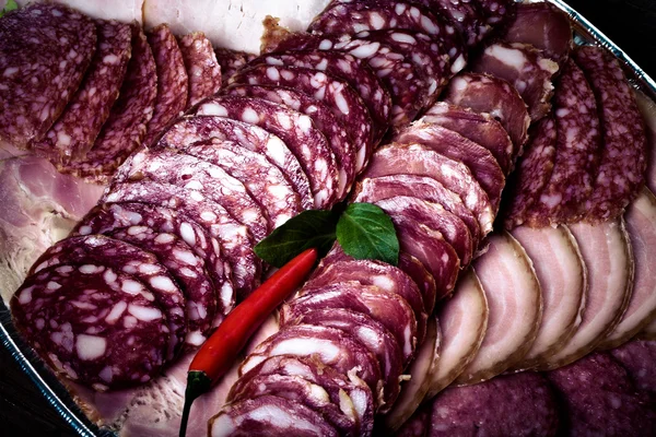 Piatto con diversi tipi di salsiccia affettata e peperoncino rosso caldo — Foto Stock