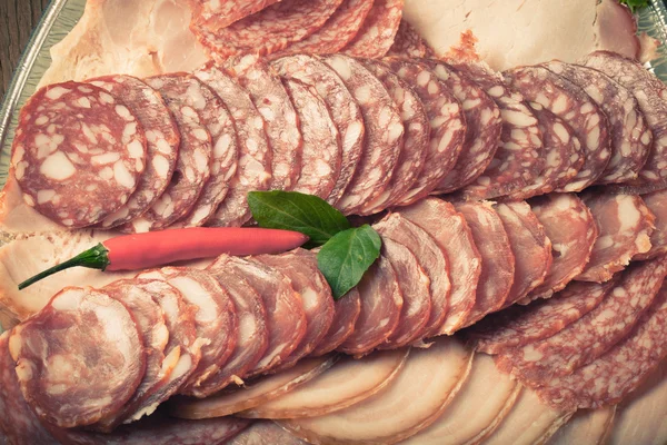 Assiette avec différents types de saucisses tranchées et de piment rouge chaud — Photo