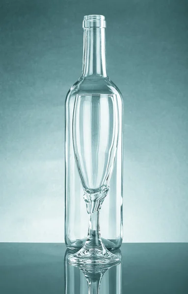 Lege fles en een leeg glas helder glas. Met reflectie — Stockfoto