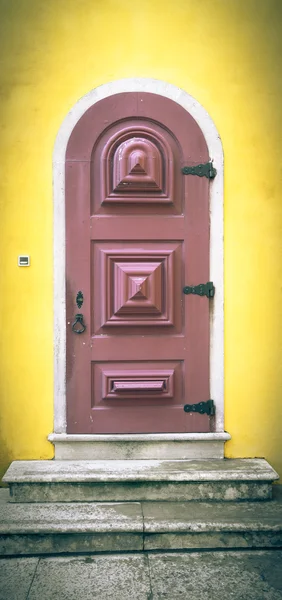 Puerta de madera vieja con bisagras metálicas y cerradura en la pared amarilla. T —  Fotos de Stock