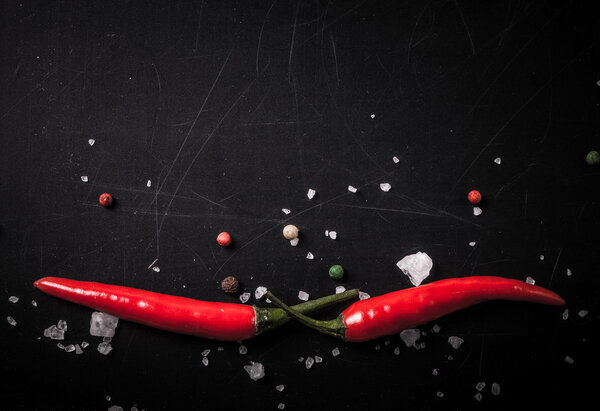 Красный острый перец чили с морской солью и цветной перец на черном
 