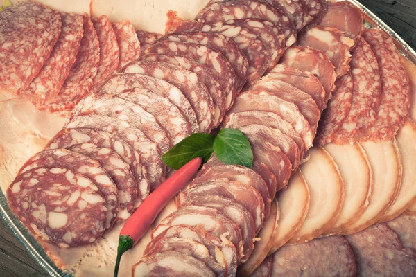 Plate with different kinds of sliced sausage and red hot chilli — Stock Photo, Image