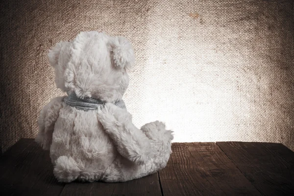 Teddy bear zit op de oude houten tafel. Afgezwakt — Stockfoto