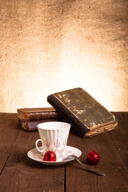 Fincan kahve, shokolad ve eski ahşap eski kitap yığını