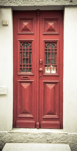 Puerta de madera roja vieja con ventana y rejilla. Tonificado — Foto de Stock