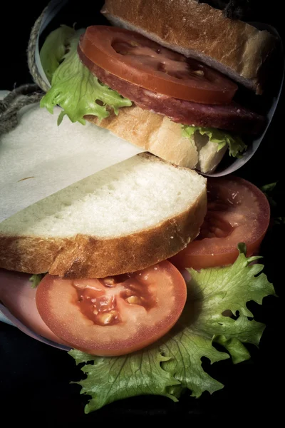Сэндвич с бечевкой на деревянной доске. Toned — стоковое фото