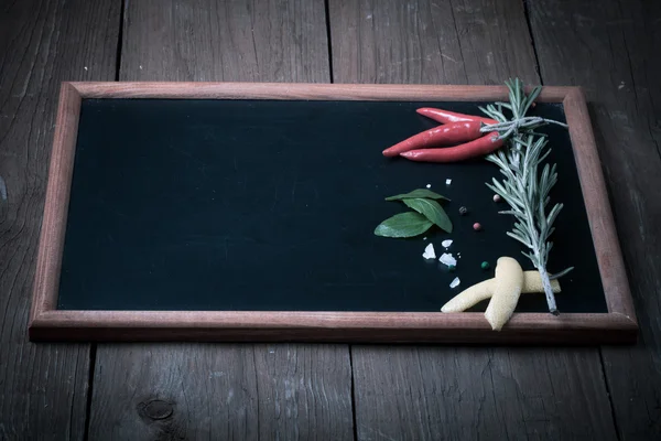 Kräuter und Gewürze. Paprika, Salz und Rosmarin auf schwarzem Backblech — Stockfoto