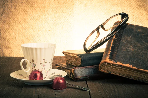 Tasse de café, shokolad, verres et pile de vieux livres sur le o — Photo