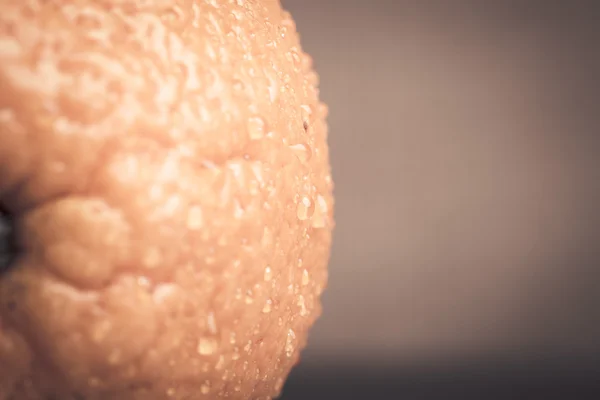 Orange z wody spadnie na zbliżenie skóry na światło backgrou — Zdjęcie stockowe