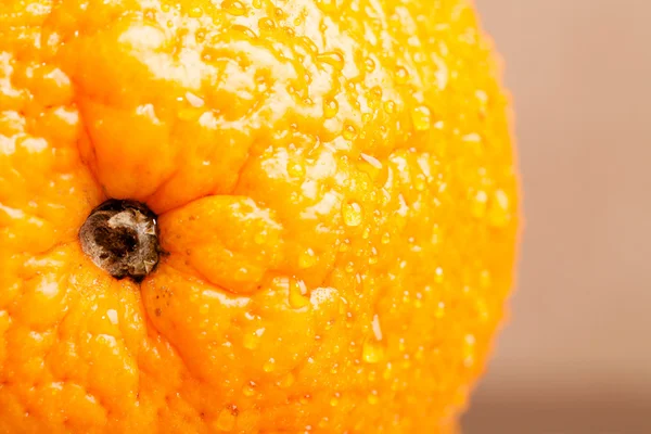 Oranje met water druppels op de huid close-up op een lichte CHTERGRO — Stockfoto