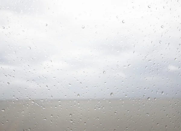 Meerblick durch die Regentropfen am Fenster — Stockfoto