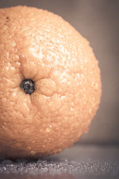 Oranje met water druppels op de huid close-up op een lichte CHTERGRO — Stockfoto