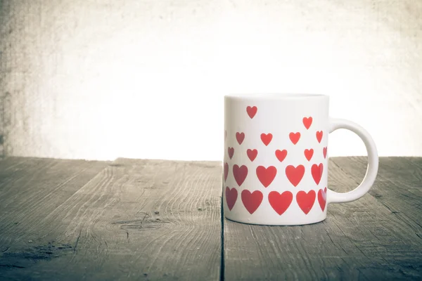 Taza con muchos corazones en la vieja mesa de madera. Tonificado —  Fotos de Stock