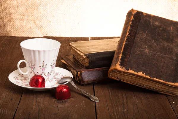 Taza de café, shokolad y pila de libros antiguos sobre la madera vieja —  Fotos de Stock