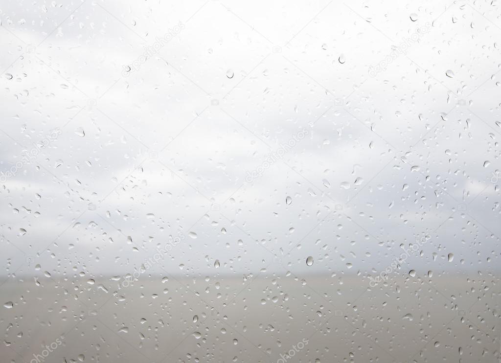 Seaview through the raindrops on window