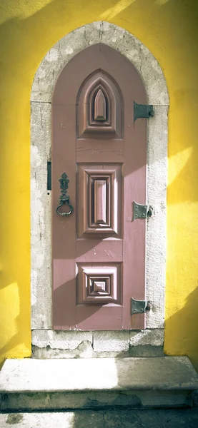 Puerta de madera vieja con bisagras metálicas y cerradura en la pared amarilla. T —  Fotos de Stock