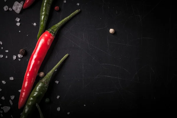 Red and green hot chilli pepper with sea salt and colored pepper — Stock Photo, Image