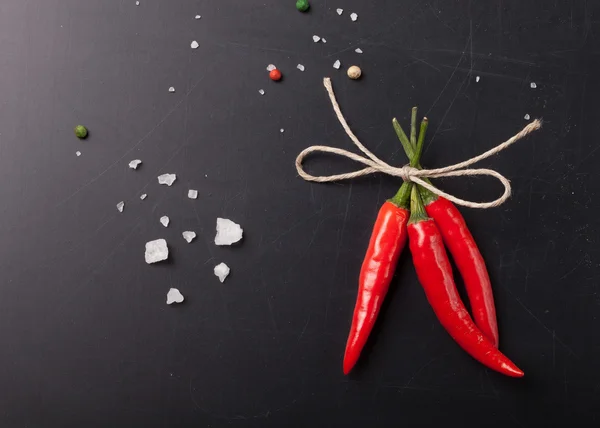 Tre heta röd chilipeppar med av garn med havssalt och co — Stockfoto