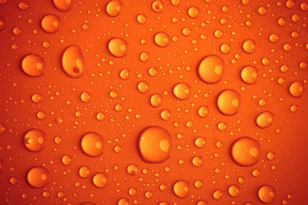 Droppar vatten på en färgad bakgrund — Stockfoto