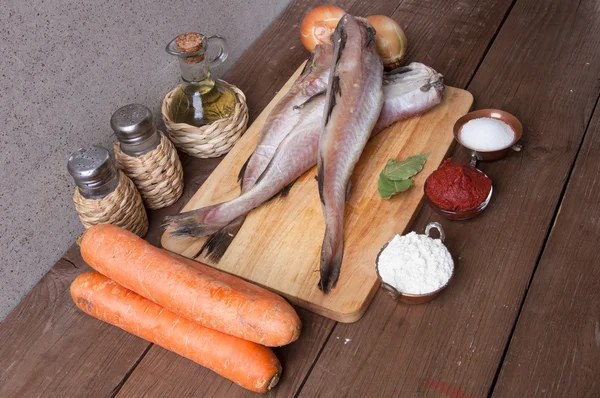 Stilleben med fisk, grönsaker och kryddor på en planka — Stockfoto
