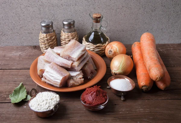 Trozos de pescado fresco en un plato, verduras, harina, tomate pasado —  Fotos de Stock