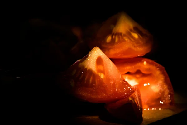 Шматочки помідорів на дерев'яній дошці. Низьке світло і дрібна деталь — стокове фото