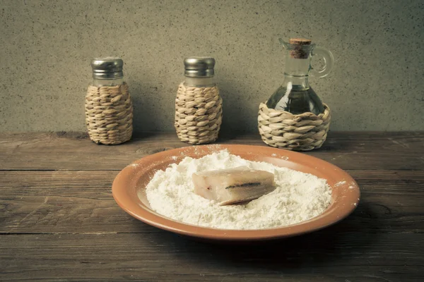 Pepe, sale, olio d'oliva e un pezzo di pesce fresco con farina o — Foto Stock