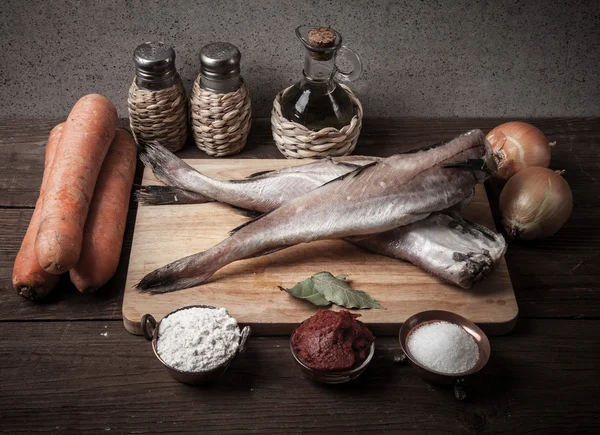 Stilleben med fisk, grönsaker och kryddor på en planka. T — Stockfoto