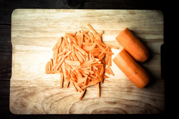 Zanahorias en rodajas en una tabla de cortar de madera. Tonificado —  Fotos de Stock