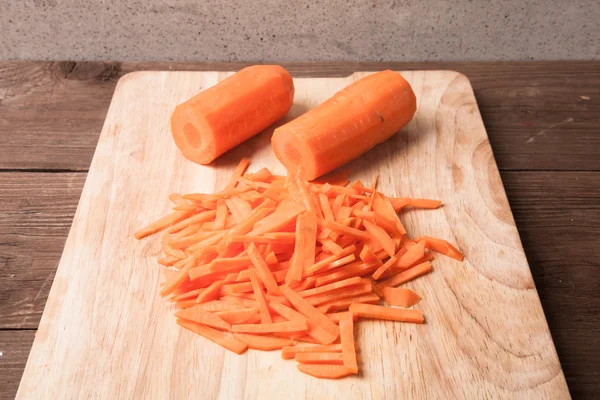 Sliced carrots on a wooden cutting board — Stock Photo, Image