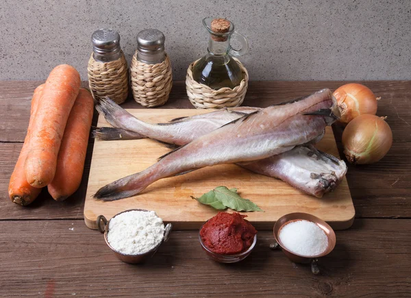 Stilleben med fisk, grönsaker och kryddor på en planka — Stockfoto