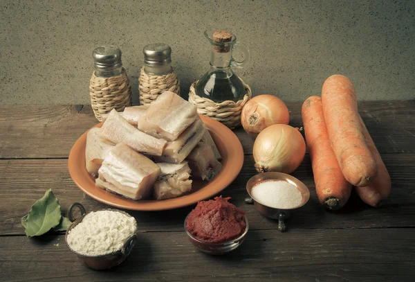 Trozos de pescado fresco en un plato, verduras, harina, tomate pasado — Foto de Stock