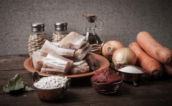 Pedaços de peixe fresco em um prato, legumes, farinha, tomate passado — Fotografia de Stock