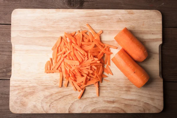 Sliced carrots on a wooden cutting board — Stock Photo, Image