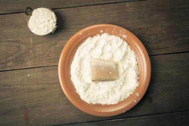Ahşap backgr üzerinde bir tabakta un ile taze balık tek parça