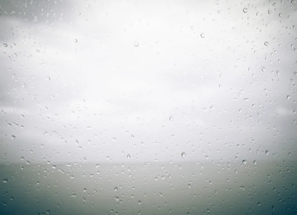 Seaview through the raindrops on window. Toned — Stock Photo, Image