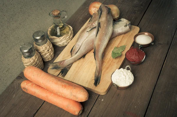 Stilleben med fisk, grönsaker och kryddor på en planka. T — Stockfoto